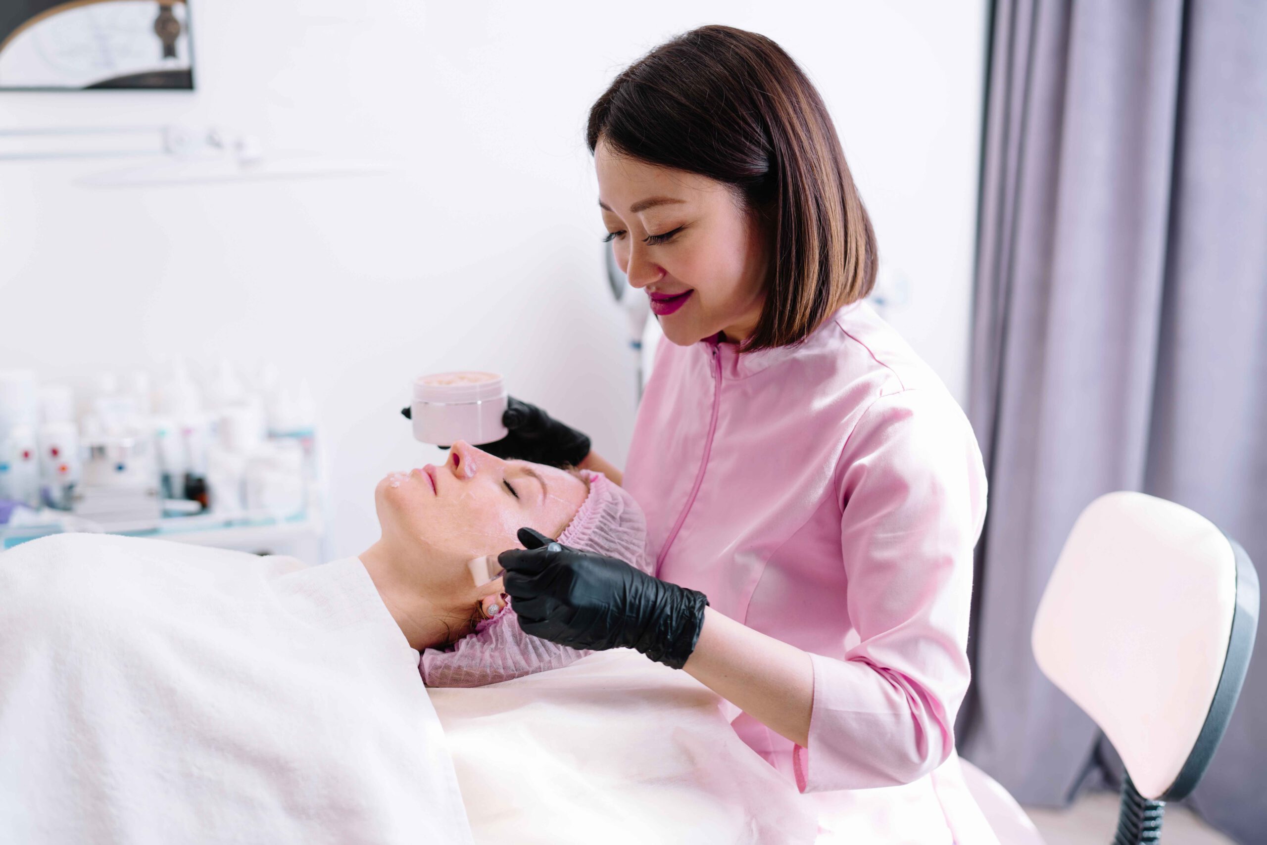 Schoonheidsspecialist behandelt een cliënt in de salon